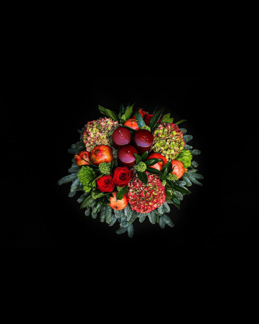 Arrangement of hydrangeas, pomegranates, roses, candles and fir 