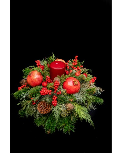 Arrangement of pomegranates, cinnamons, ilex, conifer cones, fir and. red candle.